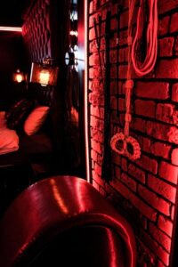 zbliżenie na ceglaną ścianę z akcesoriami erotycznymi