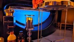 złoty stolik kawowy z różami, obok szampan i świeca