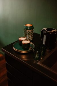 świeczki, ozdoby, czajnik na komodzie